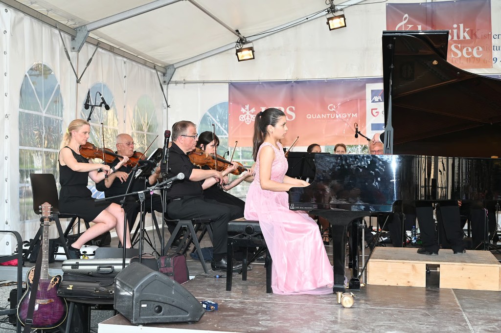 Pianistin im rosa Kleid am Flügel